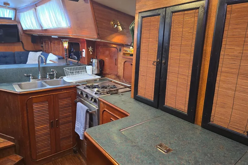 Slide: The Image of 1982 Irwin 52 yacht interior kitchen with wooden cabinets and modern appliances. - 9