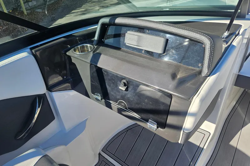Slide: The Image of 2022 Monterey M-225 boat interior with glove compartment and cup holder. - 13