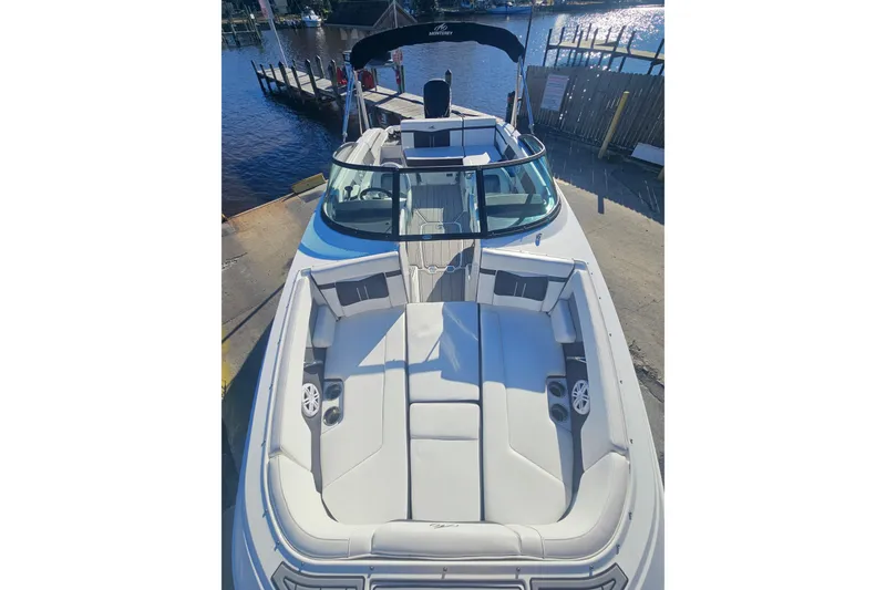 Slide: The Image of 2022 Monterey M-225 boat with spacious seating, docked by a serene waterfront. - 2