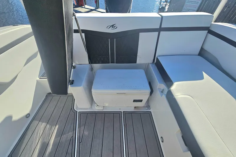 Slide: The Image of 2022 Monterey M-225 boat interior with seating and cooler on deck. - 20