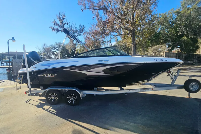 Slide: The Image of 2022 Monterey M-225 boat on trailer, parked outdoors near water. - 5