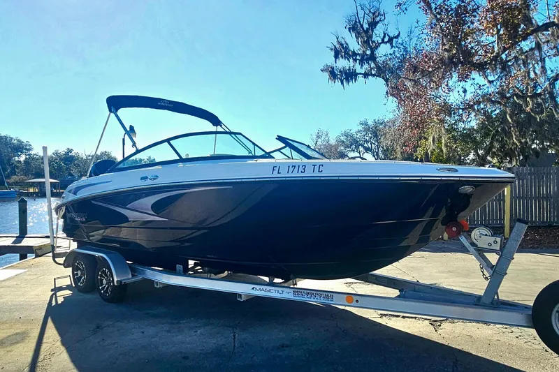 Slide: The Image of 2022 Monterey M-225 boat on trailer, parked near a scenic waterfront. - 6