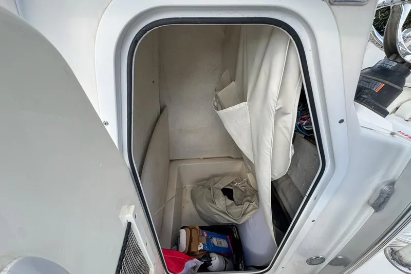Slide: The Image of Storage compartment inside a 2016 Sea Hunt Ultra 211 boat, featuring various items. - 105
