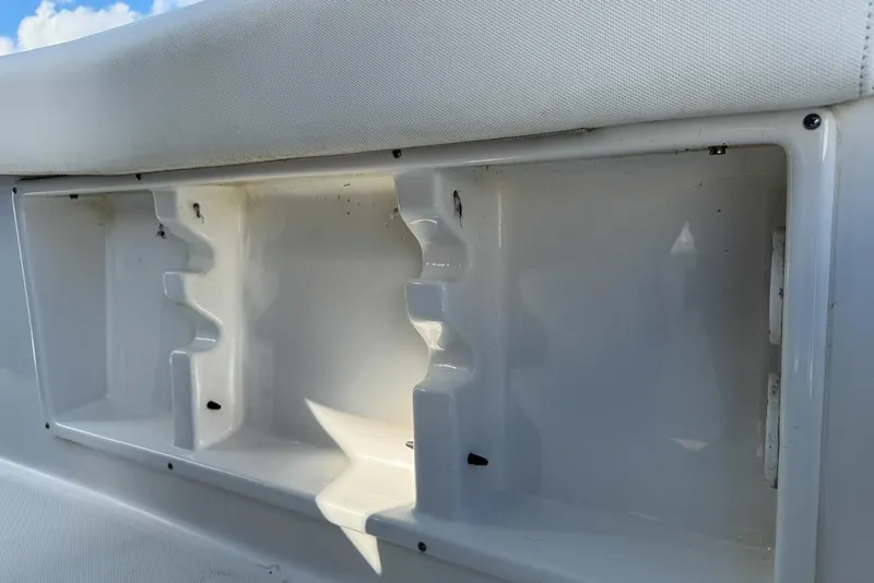 Slide: The Image of 2016 Sea Hunt Ultra 211 boat interior storage compartment, white with molded slots. - 120