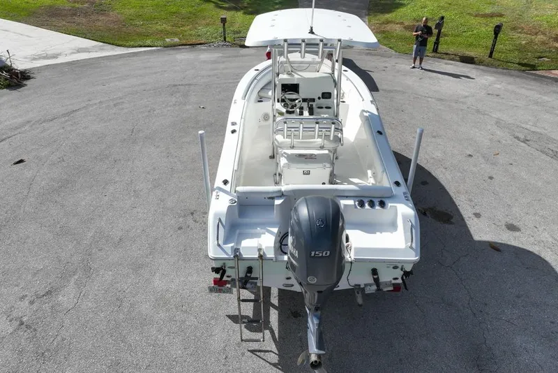 Slide: The Image of 2016 Sea Hunt Ultra 211 boat with Yamaha 150 engine, parked on pavement. - 15