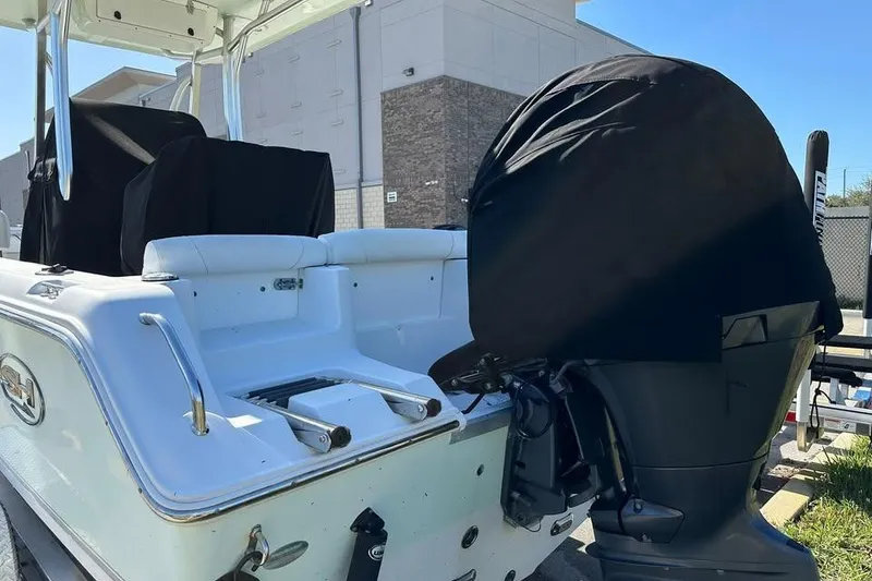 Slide: The Image of 2016 Sea Hunt Ultra 211 boat on trailer, parked outdoors under blue sky. - 2