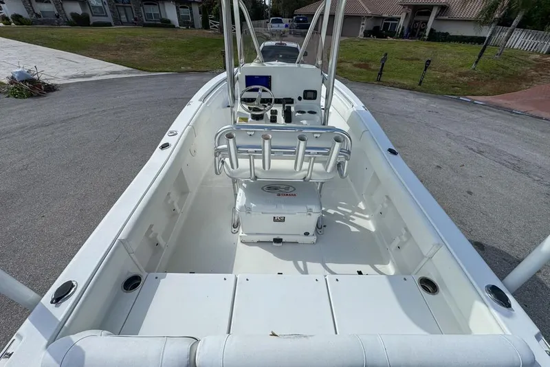 Slide: The Image of 2016 Sea Hunt Ultra 211 boat interior with console and seating, parked on a residential street. - 21