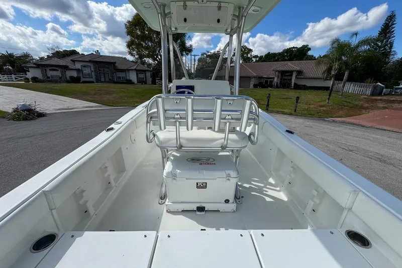 Slide: The Image of 2016 Sea Hunt Ultra 211 boat interior with seating and storage, parked in a residential area. - 23