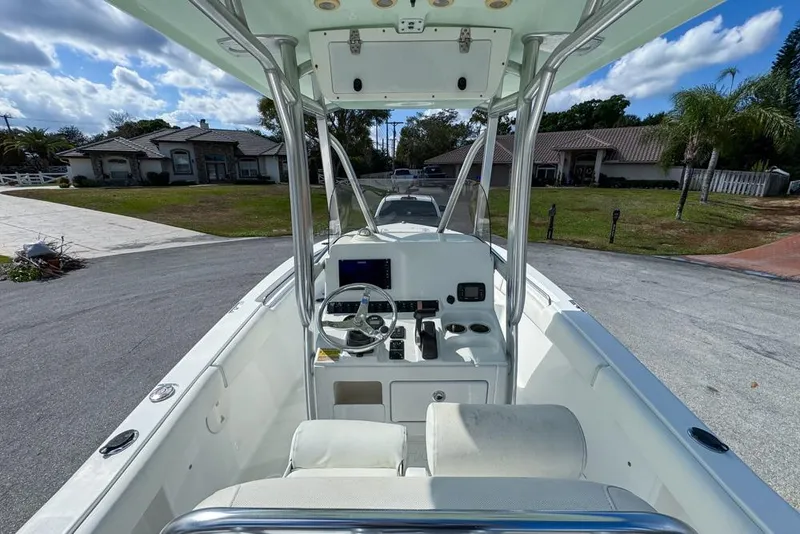 Slide: The Image of 2016 Sea Hunt Ultra 211 boat interior with steering console, parked in residential area. - 27