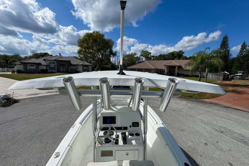 Slide: The Image of 2016 Sea Hunt Ultra 211 boat with T-top and rod holders, parked in residential area. - 30