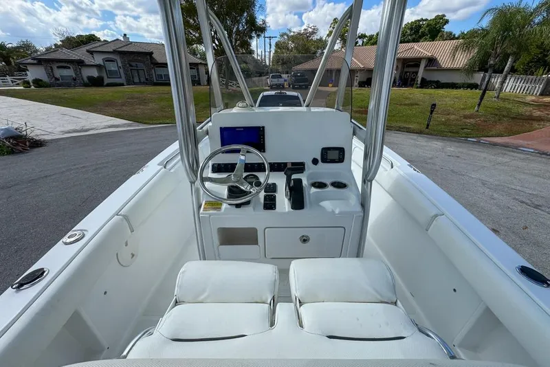 Slide: The Image of 2016 Sea Hunt Ultra 211 boat console with steering wheel and controls, parked in residential area. - 36