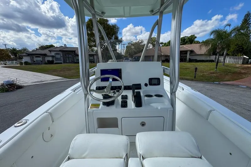 Slide: The Image of 2016 Sea Hunt Ultra 211 boat console with steering wheel and controls, parked in residential area. - 37