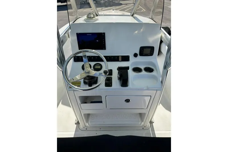 Slide: The Image of 2016 Sea Hunt Ultra 211 boat with 150 HP engine, parked on a residential street. - 5