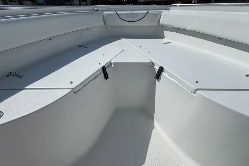 Slide: The Image of 2016 Sea Hunt Ultra 211 boat interior with white seating and storage compartments. - 54