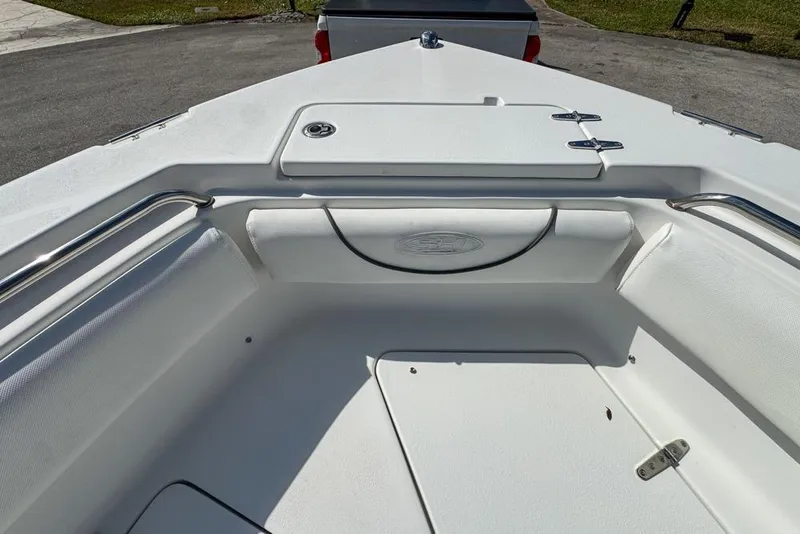 Slide: The Image of 2016 Sea Hunt Ultra 211 boat interior with white seating and storage compartment. - 57