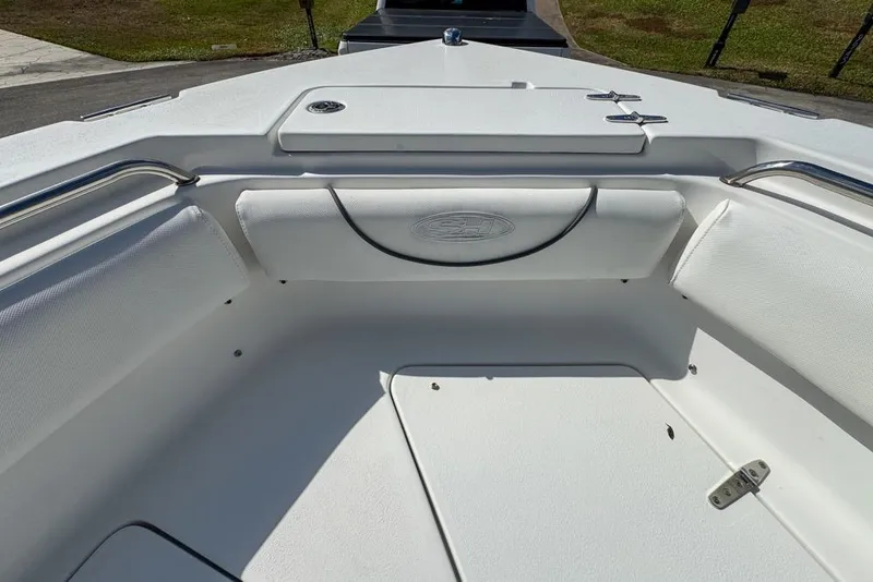 Slide: The Image of 2016 Sea Hunt Ultra 211 boat interior with white seating and storage compartments. - 58