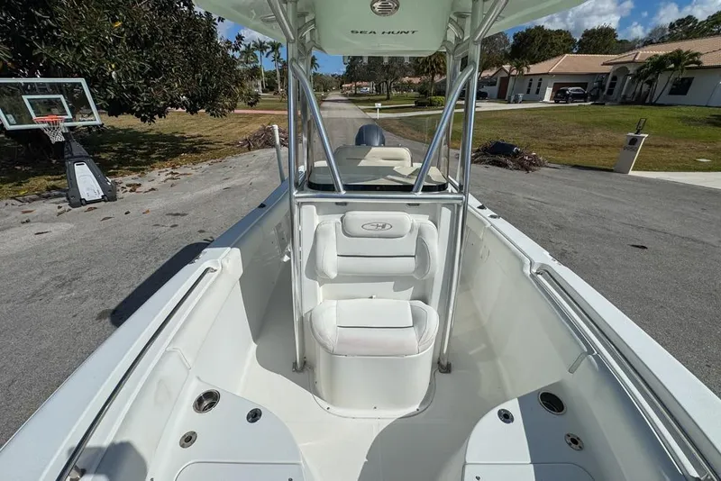 Slide: The Image of 2016 Sea Hunt Ultra 211 boat interior with seating and console, parked on a residential street. - 68