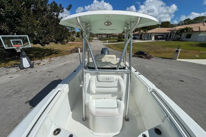Slide: The Image of 2016 Sea Hunt Ultra 211 boat with T-top, parked on a residential street. - 69