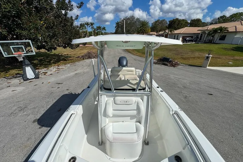 Slide: The Image of 2016 Sea Hunt Ultra 211 boat parked on a residential street, clear sky background. - 70