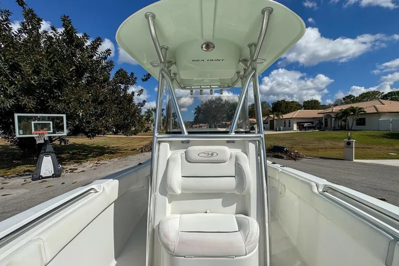 Slide: The Image of 2016 Sea Hunt Ultra 211 boat parked in residential area under clear blue sky. - 74