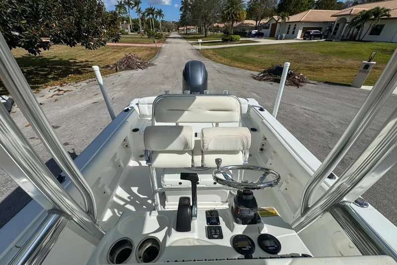 Slide: The Image of 2016 Sea Hunt Ultra 211 boat interior with steering wheel and seating, parked on a residential street. - 78