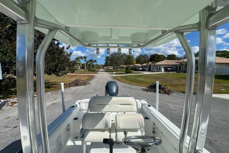 Slide: The Image of 2016 Sea Hunt Ultra 211 boat parked on a residential street, showcasing interior and helm. - 80