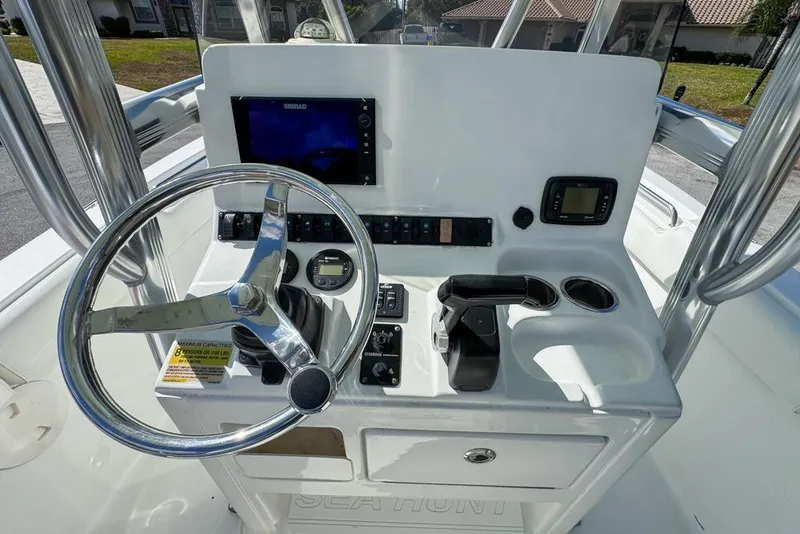Slide: The Image of 2016 Sea Hunt Ultra 211 boat console with steering wheel and navigation controls. - 83
