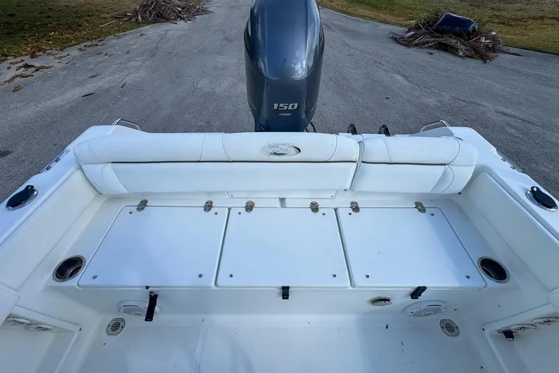 Slide: The Image of 2016 Sea Hunt Ultra 211 boat interior with Yamaha 150 engine, featuring white seating and storage compartments. - 91