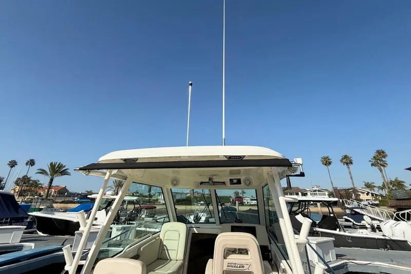 Slide: The Image of 2025 Boston Whaler 285 Conquest boat docked under clear blue sky. - 19
