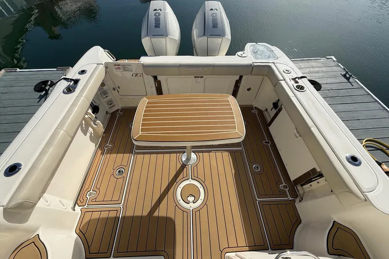 Slide: The Image of 2025 Boston Whaler 285 Conquest boat interior with wooden deck and table. - 22