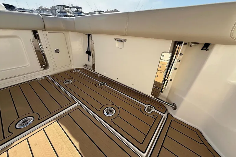 Slide: The Image of 2025 Boston Whaler 285 Conquest boat deck with teak flooring and storage compartments. - 27
