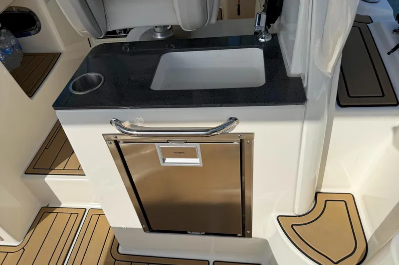 Slide: The Image of 2025 Boston Whaler 285 Conquest interior with sink and stainless steel storage. - 32