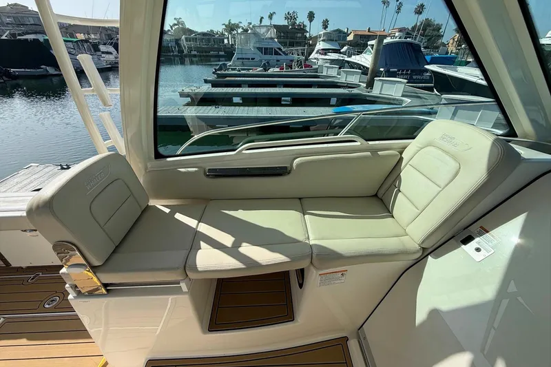 Slide: The Image of 2025 Boston Whaler 285 Conquest interior seating with marina view. - 34