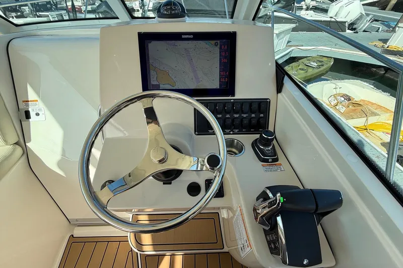 Slide: The Image of 2025 Boston Whaler 285 Conquest helm with steering wheel and navigation display. - 39
