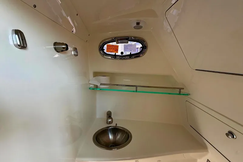 Slide: The Image of Interior of 2025 Boston Whaler 285 Conquest boat, featuring a compact sink and window. - 48