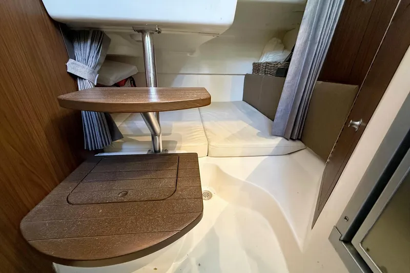Slide: The Image of Interior cabin of 2025 Boston Whaler 285 Conquest with wooden steps and cozy seating area. - 49