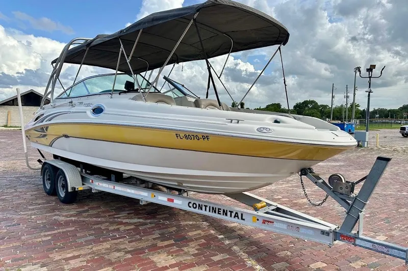 Slide: The Image of 2004 Sea Ray 270 Sundeck boat on trailer, featuring a yellow and white exterior. - 2
