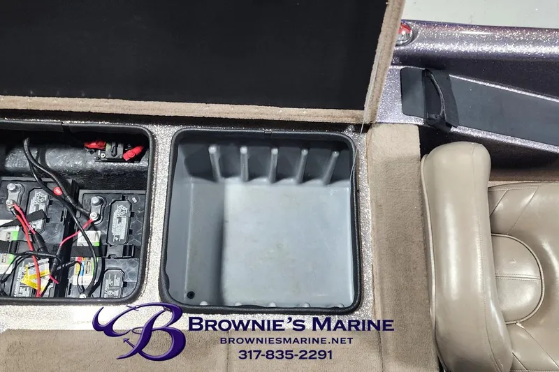 Slide: The Image of Open storage compartment in a 2003 Triton Tr-165 boat, featuring battery setup. - 11