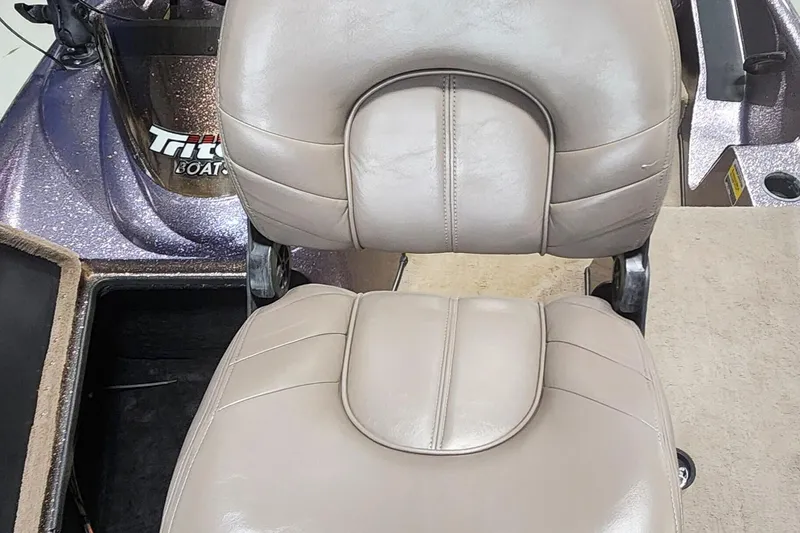 Slide: The Image of 2003 Triton Tr-165 boat seat with beige upholstery and visible logo. - 7