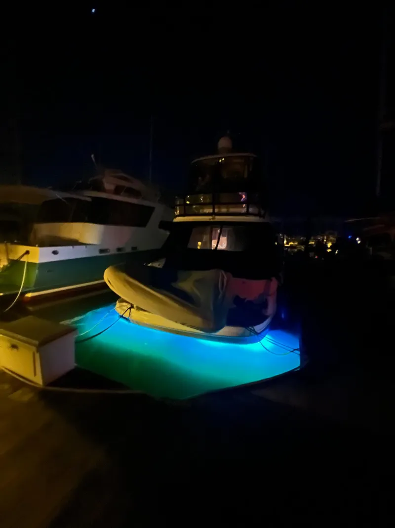Slide: The Image of 2005 Sea Ray 500 Sedan Bridge yacht with blue underwater lights at night. - 1