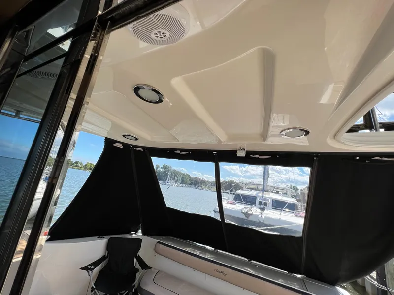 Slide: The Image of Interior view of a 2005 Sea Ray 500 Sedan Bridge yacht with black curtains and seating. - 12