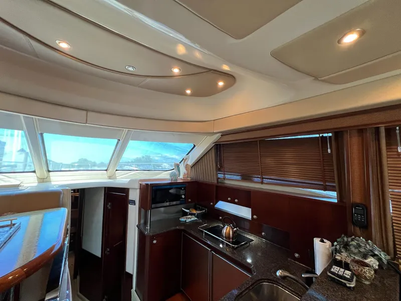 Slide: The Image of Interior of 2005 Sea Ray 500 Sedan Bridge yacht, featuring a modern kitchen area. - 14