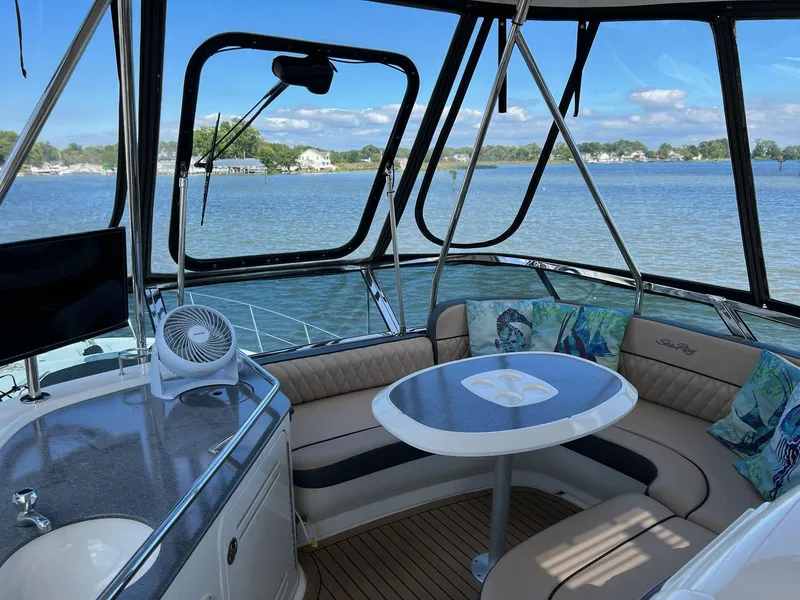 Slide: The Image of 2005 Sea Ray 500 Sedan Bridge interior with seating and table, overlooking serene water view. - 31