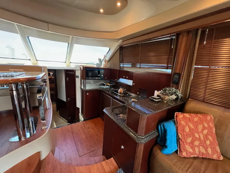 Slide: The Image of Luxurious interior of 2005 Sea Ray 500 Sedan Bridge yacht with modern kitchen and seating area. - 9