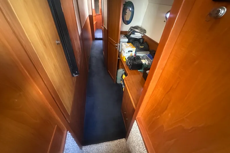 Slide: The Image of Narrow hallway inside 2002 Wright Catamaran C50 Pilot House, featuring wooden cabinetry and storage. - 14