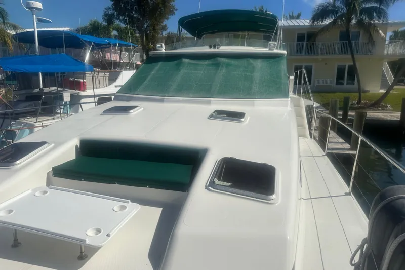 Slide: The Image of 2002 Wright Catamaran C50 Pilot House Power Catamaran docked, featuring spacious deck and green canopy. - 17