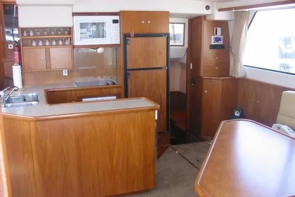 Slide: The Image of Interior of 2002 Wright Catamaran C50 Pilot House, featuring kitchen and dining area. - 6