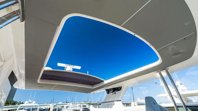 Slide: The Image of 2024 Absolute 68 NAVETTA yacht with open sunroof, showcasing clear blue sky. - 23