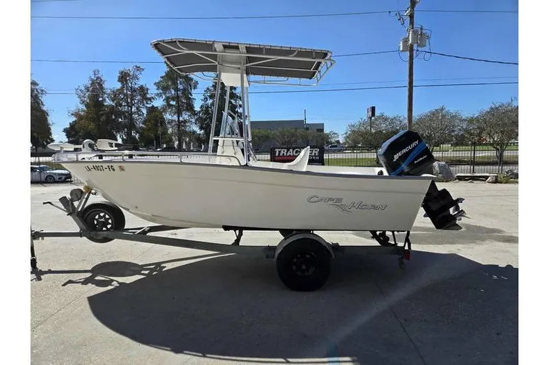 Slide: The Image of 2002 Cape Horn 17 boat on trailer with Mercury outboard motor, parked outdoors. - 1
