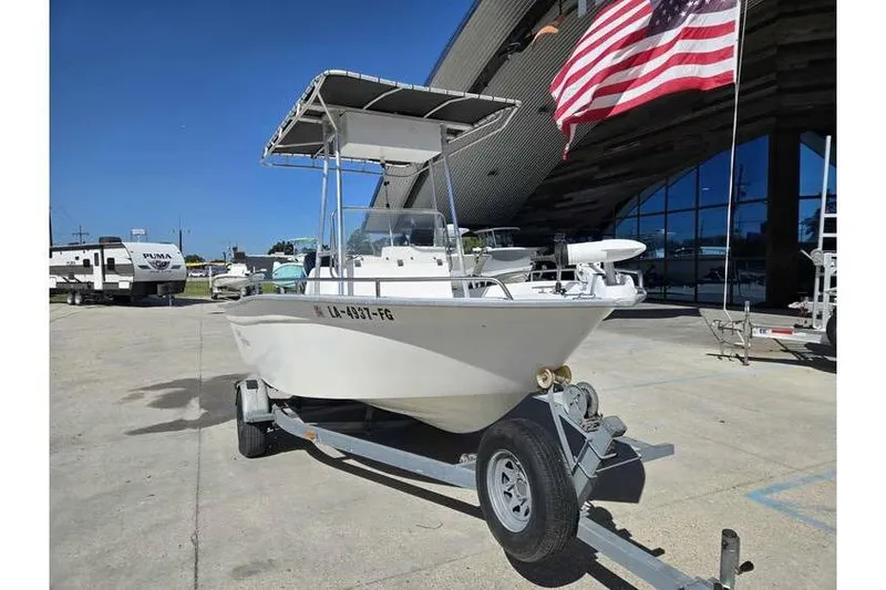 Slide: The Image of 2002 Cape Horn 17 boat on trailer, parked outdoors near American flag. - 9